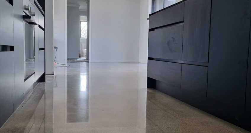 polished concrete floor in kitchen with grey cabinets
