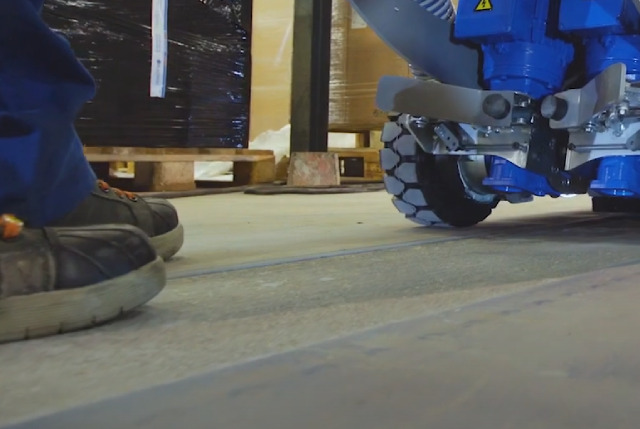 close up image of the floor beneath a concrete chase cutter showing the channel cut and mans feet in safety boots in shot