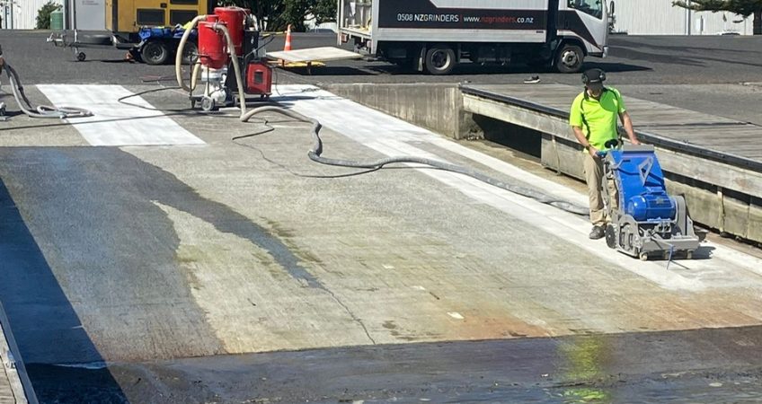 A concrete planer machine working on a boat ramp to add texture to concrete for non-slip