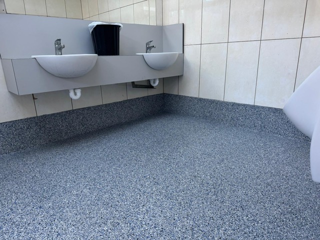 Commercial holiday park bathroom with flake flooring and coving